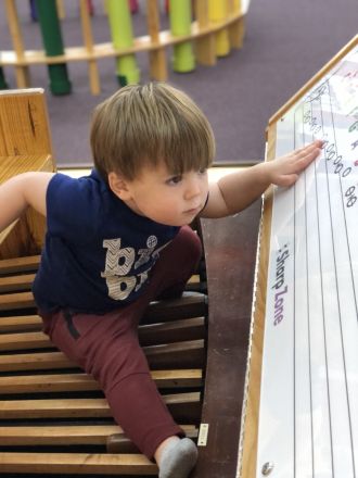 Kid playing a floor organ